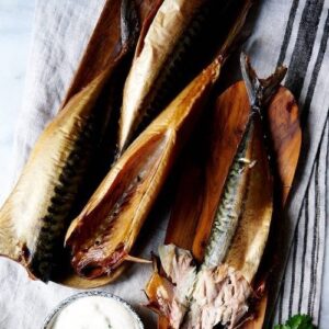 Flera varmrökta makrillfiléer på randig kökshandduk