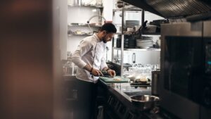 Kock förbereder råvaror vid en arbetsstation i restaurangköket