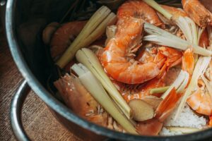Räkor och andra skaldjursrester med citrongräs i en kastrull